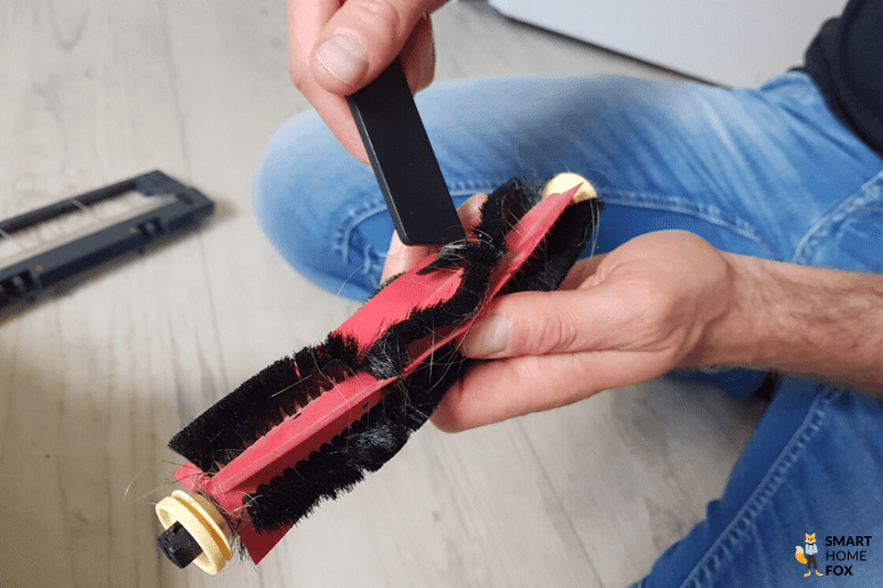Haare werden von der Hauptbürste des Staubsauger-Roboters entfernt.